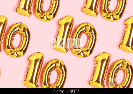 Number 10 golden balloons pattern. Ten years anniversary celebration concept on a pink background. Stock Photo