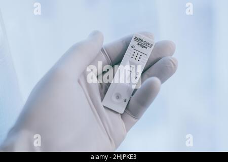 Closeup view of gloved hand with SARS-CoV-2 rapid antigen test nasal. Self test verifies positivity covid-19. Health, healthcare protection, contagion Stock Photo