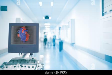 Ultrasonography equipment with heart image on the screen in the ER hallway with working doctors. Concept of an emergency care in a hospital with heart Stock Photo