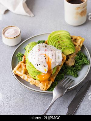 Waffles with avocado and poached egg Stock Photo