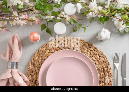 Easter pink dinner with white bunny, fresh spring flowers and egg. Festive table setting for happy Christian religion holiday. Stock Photo