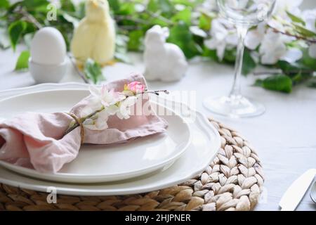 Easter table setting with yellow chick,decorations, fresh flowers and eggs. Elegance dinner. Close up. Stock Photo