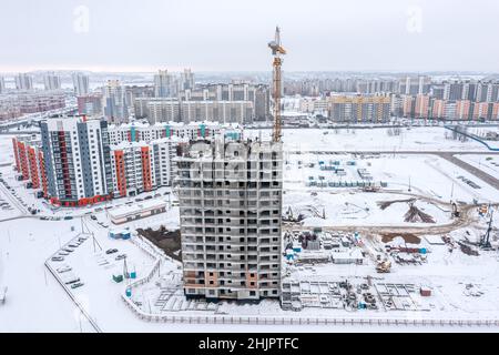 construction of new high-rise apartment building in residential district at winter time. aerial drone photo. Stock Photo