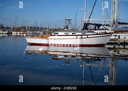 Reflections in the water of a boat in Birdham Pool Marina which is situated in Chichester Harbour. Stock Photo