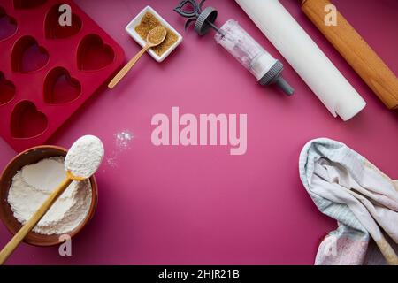 Preparing for baking: heart-shaped silicone mold, rolling pin, confectionery syringe, glaze, flour, sugar. Valentine's day concept. Copy space. High quality photo Stock Photo
