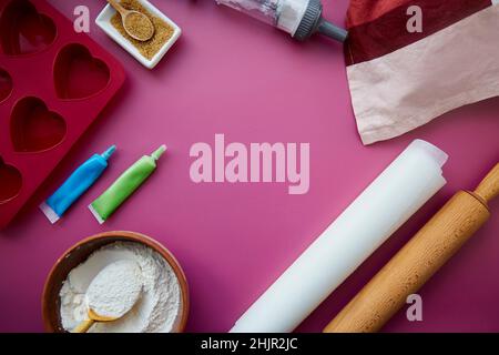 Preparing for baking: heart-shaped silicone mold, rolling pin, confectionery syringe, glaze, flour, sugar. Copy space. Valentine's day concept. High quality photo Stock Photo
