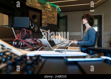 Young curly hair caucasian woman working in a music studio Stock Photo
