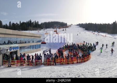 Bialka Tatrzanska, Poland - February 23, 2021: Skiers wait in line to the ski lift at the ski slope in popular winter resort Kotelnica Bialczanska dur Stock Photo