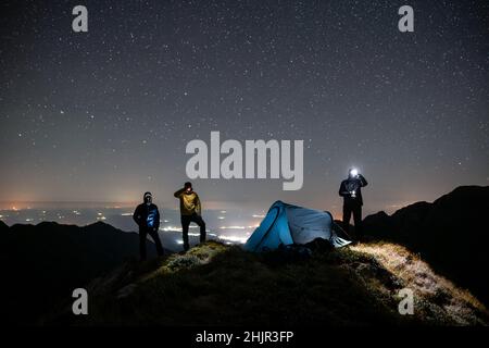 Man standing with headlamp under the sky full of stars Stock Photo