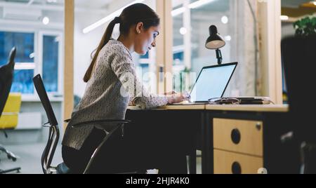 Serious female student working on laptop Stock Photo