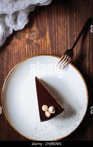 Chocolate hazelnut cake with five layers of biscuit and cream with chocolate glazing on top and whole nuts from Piemont. Served and decorated with cof Stock Photo