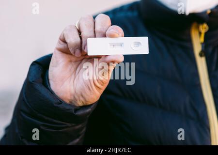 Detail of the hand of an elderly woman in the street holding a negative antigen test. Concept covid-19, ihu, delta, omicron, detection test and pandem Stock Photo