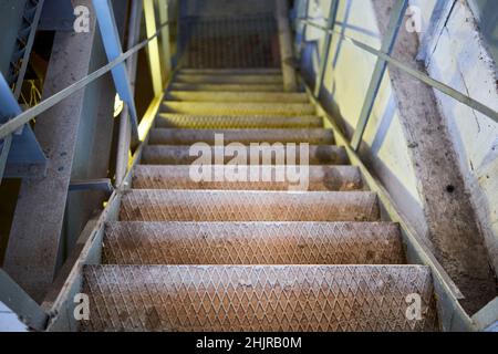 Example of chemical plant steampunk retro style interior part with copyspace. Abstract image of industrial textured rusted stairs going down vertical Stock Photo