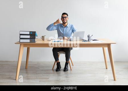 Portrait of smiling Arab man making call me gesture Stock Photo