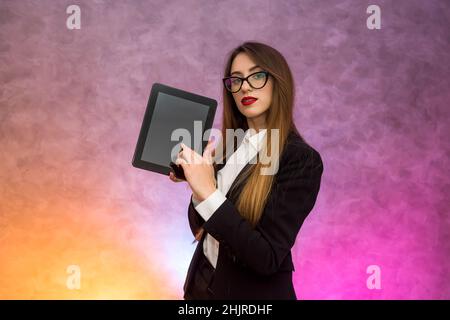 Cute woman in glasses using tablet on abstract background. Business concept Stock Photo