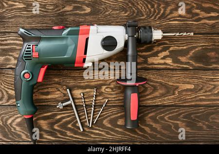 Professional electric drill-perforator with handle on wooden background Stock Photo