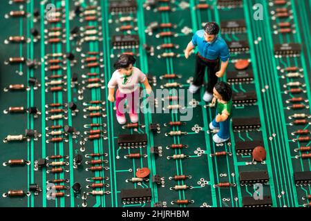 Close Up of toy people on green electronic circuit board Stock Photo