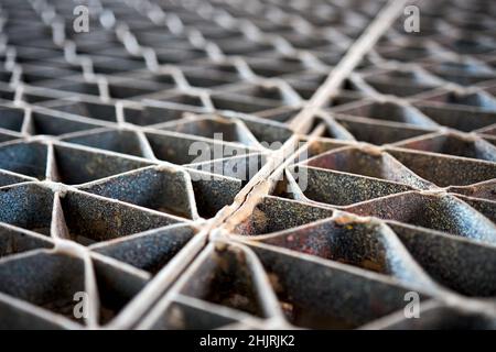 Metal industry steel grade sheet or floor grating with multicolored drops of paint macro closeup. Shallow depth of field diminished perspective Stock Photo