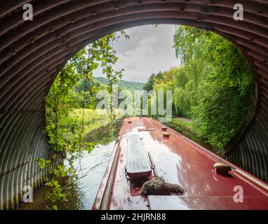 A canal boat emerging from underneath a bridge on the Rochdale canal near Sowerby Bridge Stock Photo
