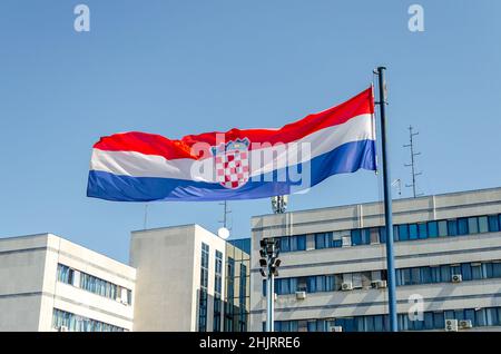 Close Up View of a Croatian Flag Waving Proudly Under the Bright Blue Sky on a Sunny Day in Pula, Croatia. Buildings in Background. Stock Photo