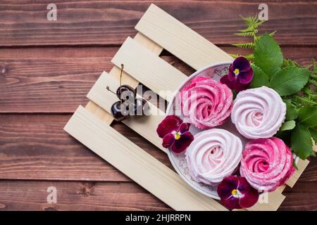 A close up view of a stack of toasted meringues topped with berries ready for eating. Stock Photo