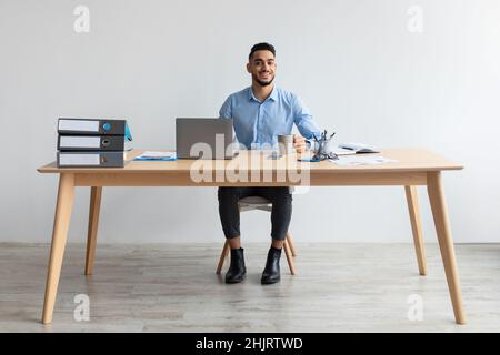 Portrait of smiling Arab man using laptop and posing Stock Photo
