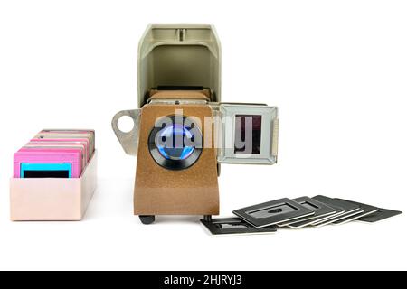 Old slide projector and set of slides isolated on white background. Retro equipment. Stock Photo
