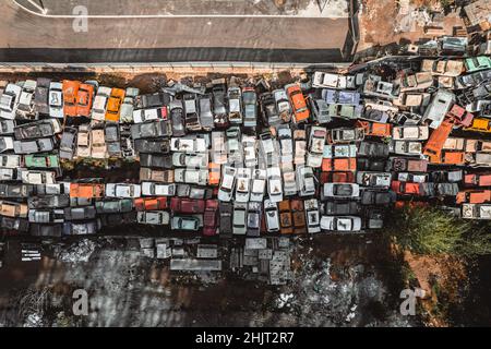 Aerial view of a Soviet automobile dump from a drone. Shooting from above at heaps of rusty cars. Abandoned Russian cars awaiting disposal and