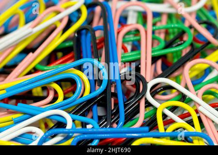 Close up abstract still life of a disorganised mass of coloured paperclips. Stock Photo