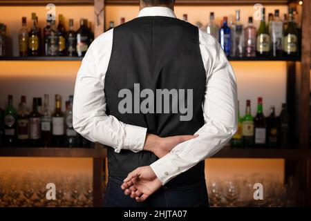 Backside of elegant bartender selecting beverage for customers in restaurant. High quality photo Stock Photo