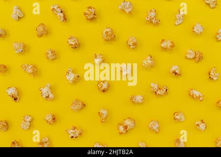 pattern of caramel popcorn on yellow background, sweet snacks, top view, close-up Stock Photo