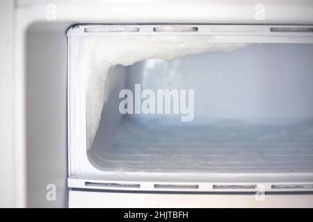 Fridge freezer with frozen ice. Maintenance and defrosting of the refrigerator. Stock Photo