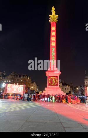 London UK 31st Jan 2022:  Nelson column is seen illuminated in mandarin on Chinese New year's eve to wish people a Happy Chinese New Year (Lunar New Year). The usual Chinese New Year celebrations have been cancelled this year. A small ceremony of lion and dragon dancing were performed at London Trafalgar square to Londoners, vips and dignitaries, representatives from mayor of London office, lord mayor of Westminster. Credit: Xiu Bao/Alamy Live News