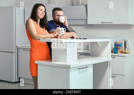 White kitchen in flat of newlyweds and couple have breakfast. Stock Photo