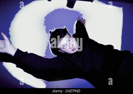 a young woman jumps through the picture her arms are stretched upwards Stock Photo