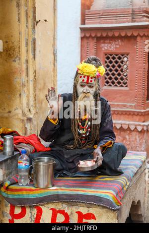 Hindu lifestyle: portrait of a typical sadhu or holy man with raised hand in blessing in Varanasi , a city on the River Ganges in Uttar Pradesh, India Stock Photo