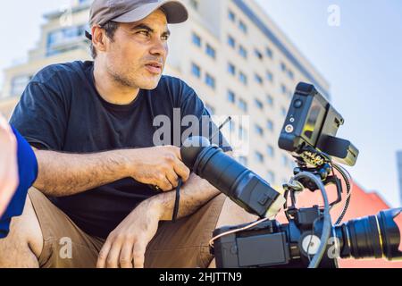 Shooting process on cinema stage - commercial production set, exterior location.Profeccional cameraman operates the camera Stock Photo