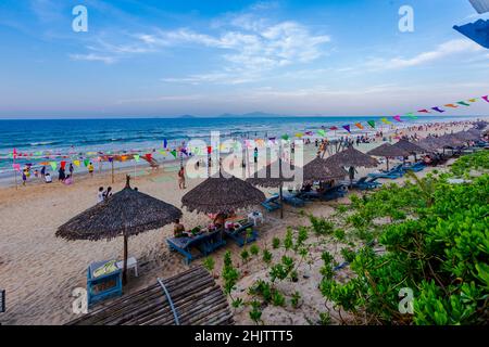 A nice day at An Bang Beach with lots of tourists relaxing in the shaded lounge chairs and blue ocean and sky. Stock Photo