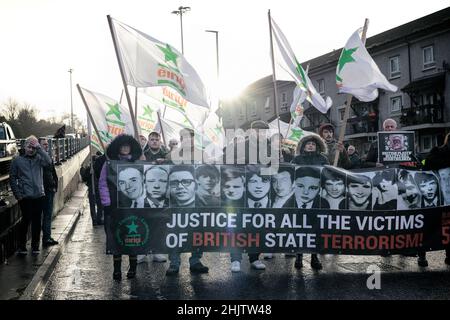 Derry, UK. 30th Jan, 2022. Demonstrators hold banners and flag as they march in remembrance for those killed and injured during the 1972 Bloody Sunday massacre on the 50th anniversary of the tragedy.Hundreds of people gathered in Derry on Sunday to pay their respects to the relatives of those who were killed in the Bloody Sunday massacre fifty years ago. On January 30th, 1972, civil rights activists who marched in Derry were shot at by British paratroopers resulting in the death of 14 people and the injuries of dozens more. Credit: SOPA Images Limited/Alamy Live News Stock Photo