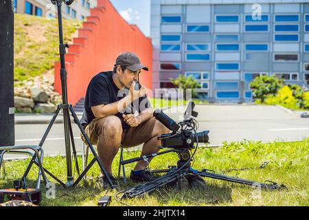 Shooting process on cinema stage - commercial production set, exterior location.Profeccional cameraman operates the camera Stock Photo