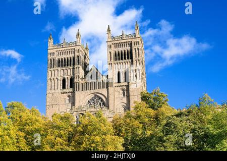 A view looking up at the exterior of Durham Cathedral on a sunny day with blue sky and clouds, Durham City, County Durham, North East England, UK Stock Photo