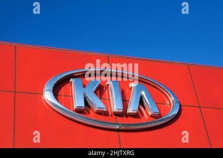  Signo del logotipo de la empresa de la marca KIA Motors en un concesionario de automóviles contra el cielo azul Foto de stock