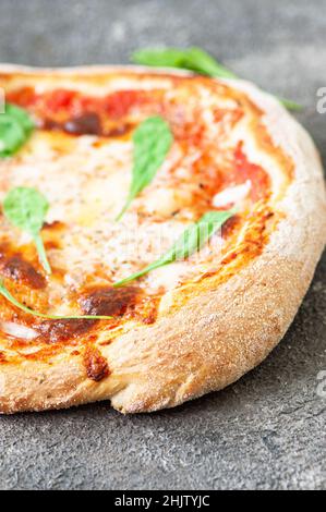 Freshly baked Italian pizza on a gray background. Close up. Stock Photo
