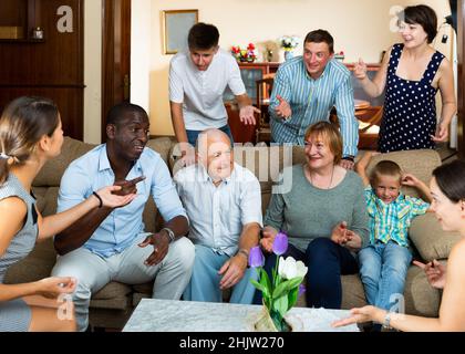Portrait of big multigenerational family chatting on sofa Stock Photo
