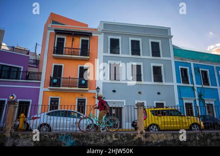 A cyclist passes the colorful facades of historic buildings in Old San Juan, Puerto Rico Stock Photo