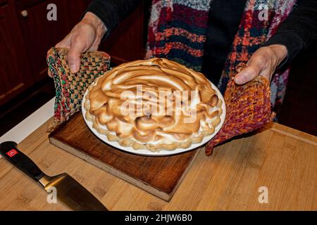 Woman holding finished baked Alaska just removed from oven. St Paul Minnesota MN USA Stock Photo