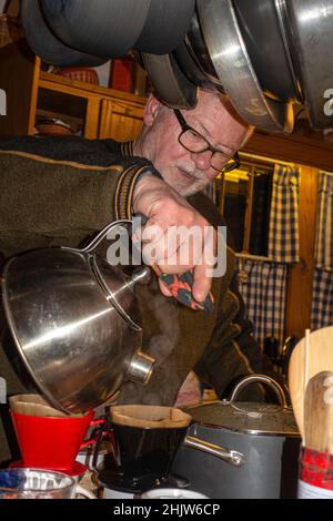 Man pouring hot water through filter for coffee. St Paul Minnesota MN USA Stock Photo