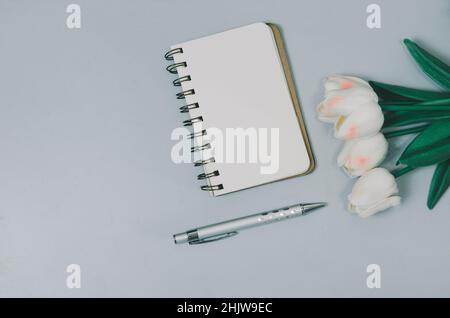 Top view flat lay notebook and flower and pen on table.Copy space Stock Photo