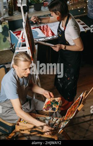 Creative group workshop of painting on big canvas in studio. students painting at art lessons. Art education for adults. Hobby and work  Stock Photo