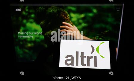 Person holding smartphone with logo of Portuguese conglomerate Altri SGPS S.A. on screen in front of website. Focus on phone display. Stock Photo